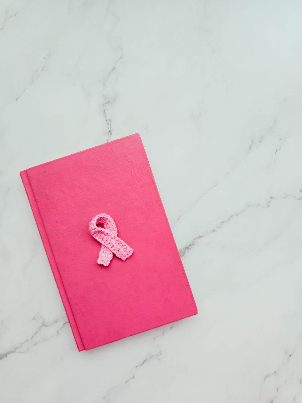 pink notebook with breast cancer awareness ribbon
